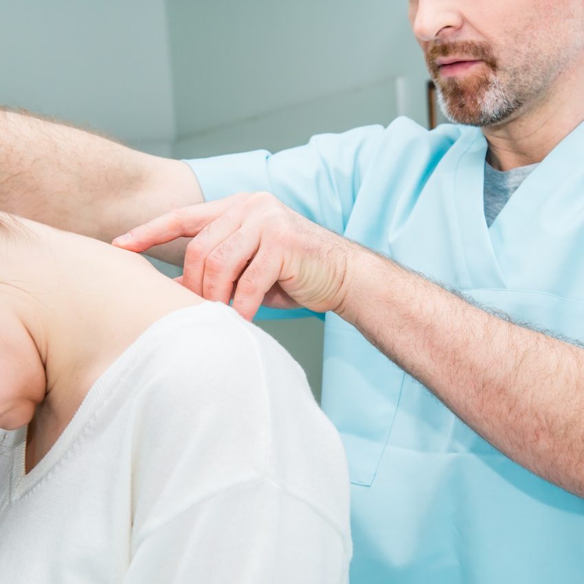 neurologist doctor examines cervical vertebrae of the female patient spinal column in medical clinic